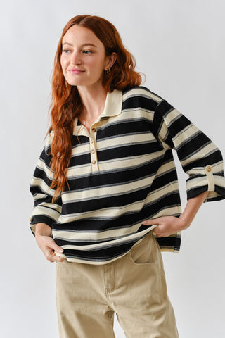 Woman wearing a black and white striped shirt with a plain background