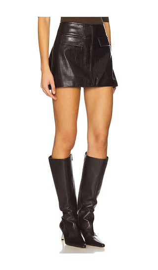 Person wearing a black leather skirt and boots on a white background