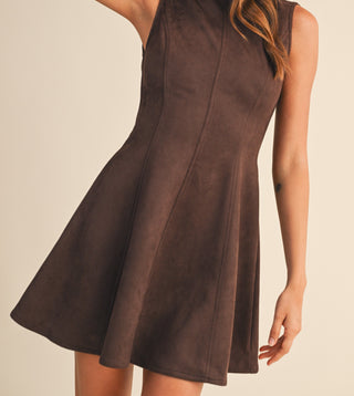 Woman wearing a brown sleeveless dress against a beige background