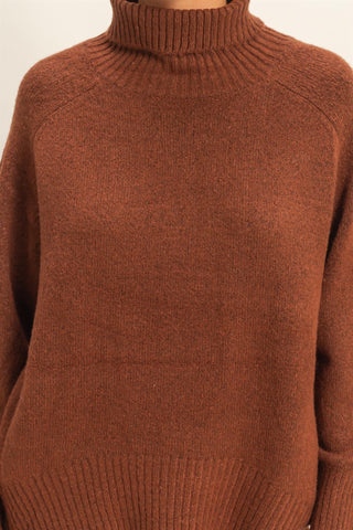 Brown knitted sweater with a turtleneck on a neutral background
