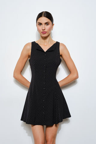 Woman wearing a black polka dot dress against a white background