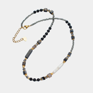 Necklace with black, gold, and gray beads with mother of pearl.