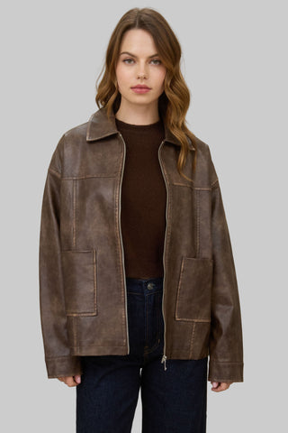 Woman wearing a brown leather jacket on a gray background