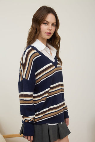 Woman wearing a striped sweater with a plain background