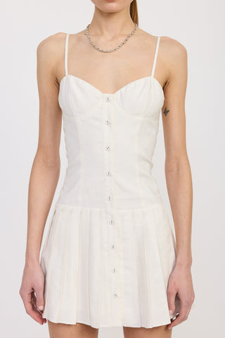 Close-up of white mini dress with button-down front, pleated skirt, and sweetheart neckline.