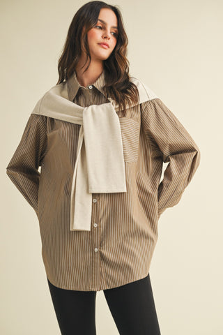 Woman wearing a brown striped shirt with a beige scarf on a beige background