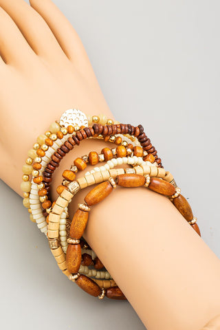 Stack of beaded bracelets on a wrist against a neutral background