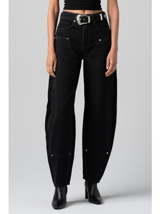 Person wearing black jeans on a gray background