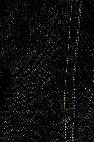 Close-up of black denim fabric with visible stitching