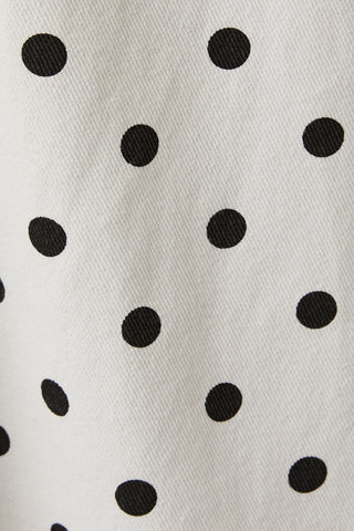 Close-up of a fabric with black polka dots on a white background