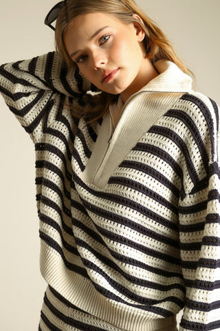 Woman wearing a black and white striped sweater against a beige background