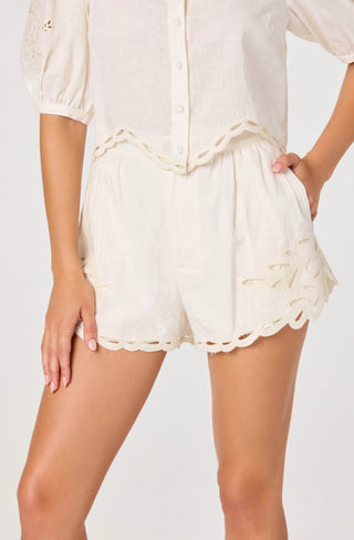 Person wearing a white lace-trimmed outfit on a plain background