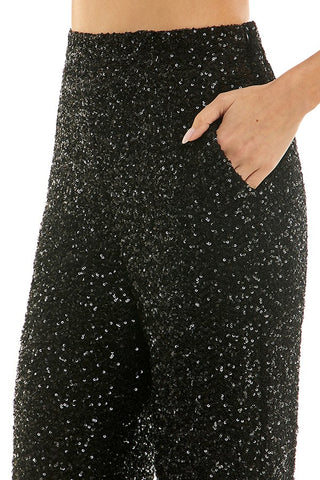 Black sequin skirt worn by a person on a white background