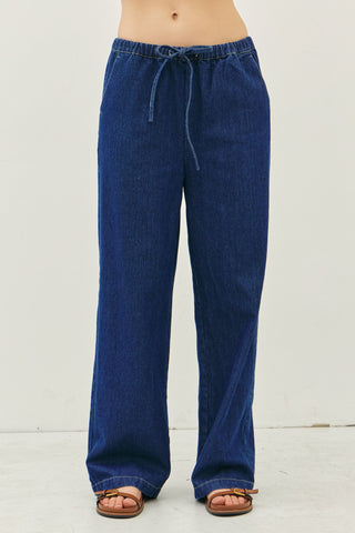 Blue denim pants worn by a person on a white background