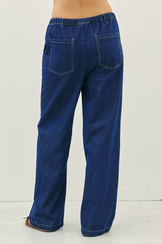 Blue denim drawstring pants shown from the back, highlighting the two back pockets