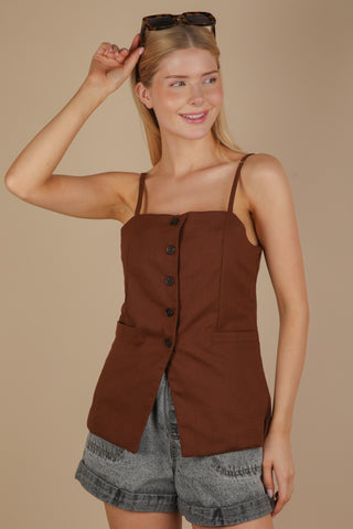 woman wearing brown button down top showcasing black buttons featuring split at waist.