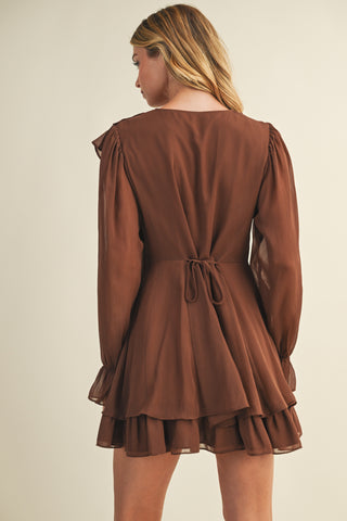 Brown dress with long sleeves and a tie waist on a plain background