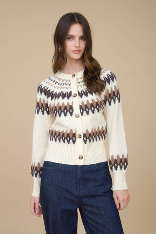 Woman wearing a cream cardigan with a black and brown pattern on a beige background