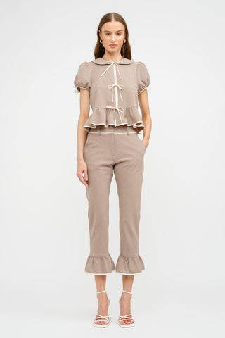 Front view of taupe gingham printed blouse featuring tie-front detailing. Designed to pair with the matching Nelly Gingham Pant for a coordinated set. Model is wearing a size small.