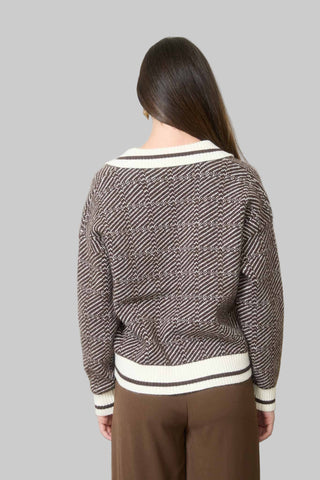 Person wearing a patterned sweater in an office setting