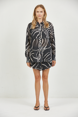 Woman wearing a black and white patterned dress on a white background