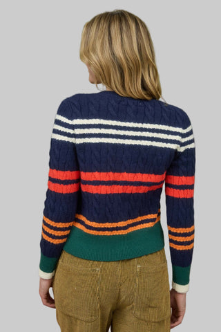 Person wearing a striped sweater with a green background