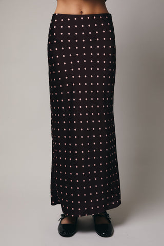 Black skirt with white polka dots on a plain background