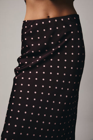 Black polka dot skirt draped over a person on a gray background
