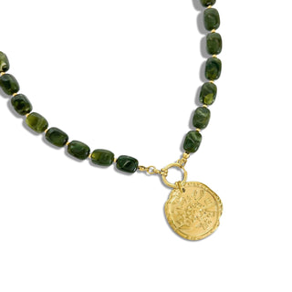 A beaded necklace featuring dark green faceted stone beads and a gold-tone coin pendant, displayed on a clean white background.