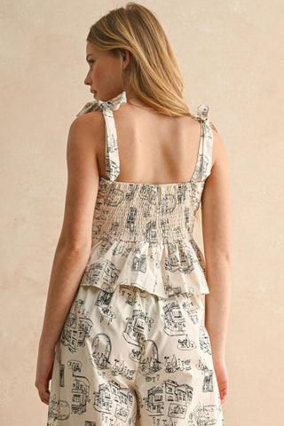 Back view of cream printed ruffle top with smocked panel and tie shoulder straps, styled with matching bottoms.