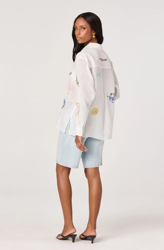 Woman wearing a white jacket with colorful patches on a white background