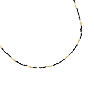 Necklace with black beads and gold chain on a white background