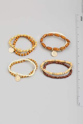 Set of four beaded bracelets with charms on a gray background, accompanied by a ruler for size reference.