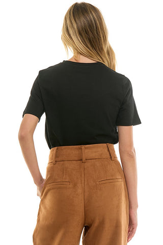 Person wearing a black t-shirt and brown pants on a white background