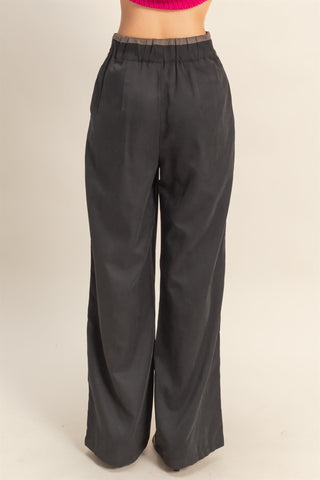 Black wide-leg pants on a beige background