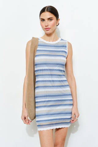 Woman wearing a blue and white striped dress on a white background