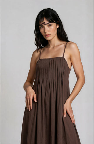 Woman wearing a brown dress against a plain background