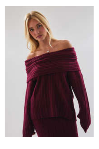 Woman wearing a burgundy off-shoulder top against a plain background