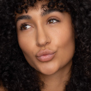 Close-up of a person with curly hair, focusing on the face.