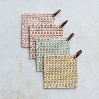 Set of four handwoven cotton crochet pot holders in assorted pastel colors with leather hanging loops, stacked flat on white background.