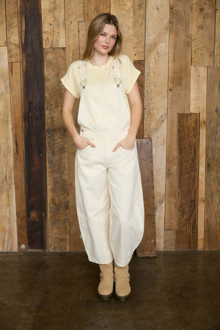 Woman wearing a white outfit with a wooden panel background