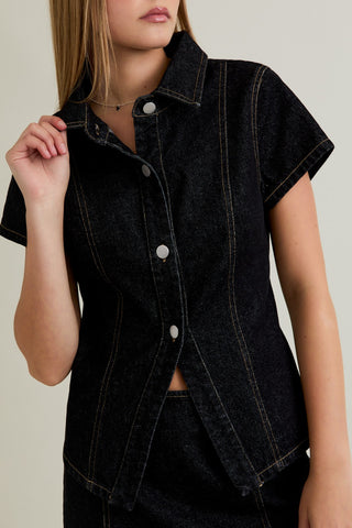 Black denim vest worn by a person on a neutral background