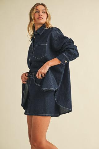 Woman wearing a blue denim dress against a beige background