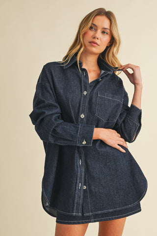 Woman wearing a denim dress against a beige background