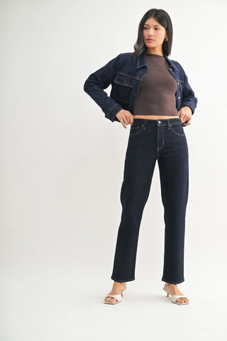 Woman wearing a denim jacket and jeans on a white background