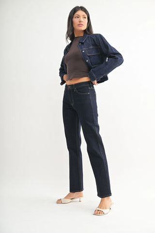 Woman wearing a denim jacket and jeans on a white background
