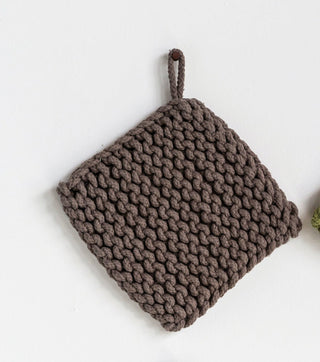 Four knitted pot holders in brown, green, black, and gray on a white background