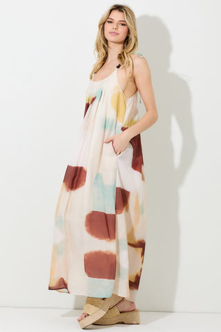 Model wearing Fayola watercolor maxi dress with tie-shoulder straps and front pockets, shown from front view