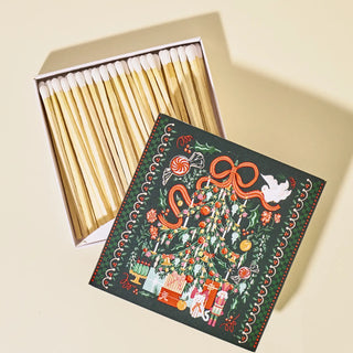 Matches with a decorative box featuring a Christmas tree design on a beige background