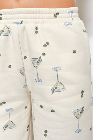 Beige sweatpants with cocktail glass and olive pattern on a white background